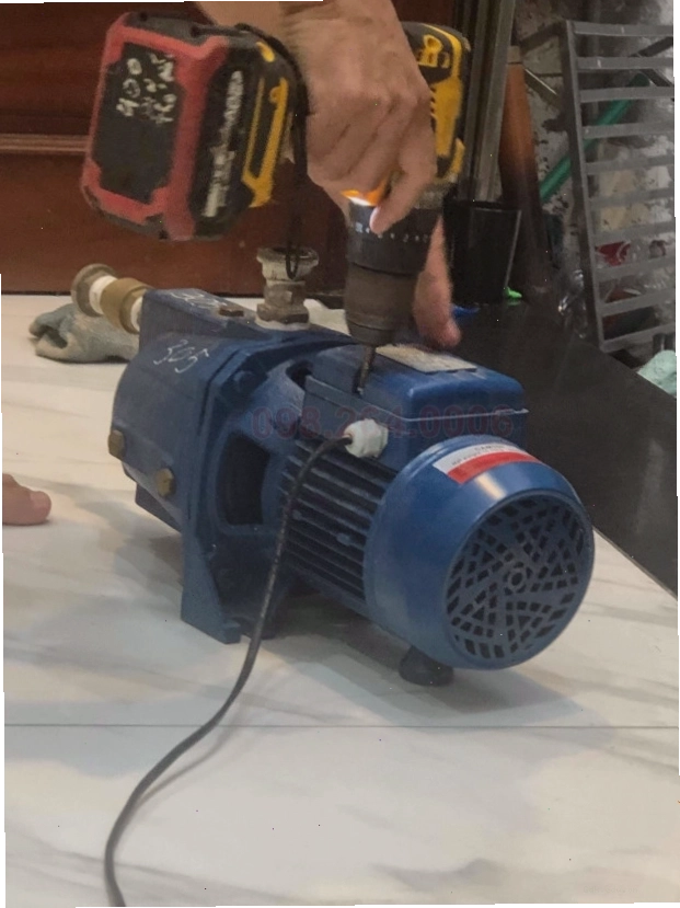 Thợ kỹ thuật đang kiểm tra các chi tiết bên trong máy bơm nước gia đình